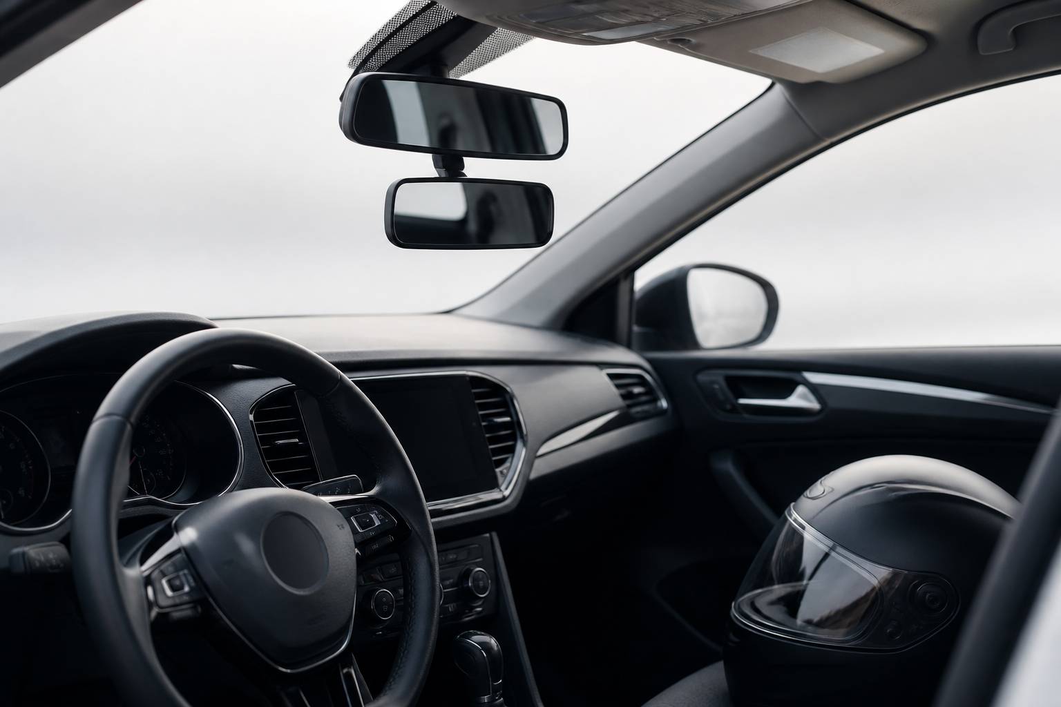Tableau de bord de voiture avec double rétroviseur et un casque posé sur le siège