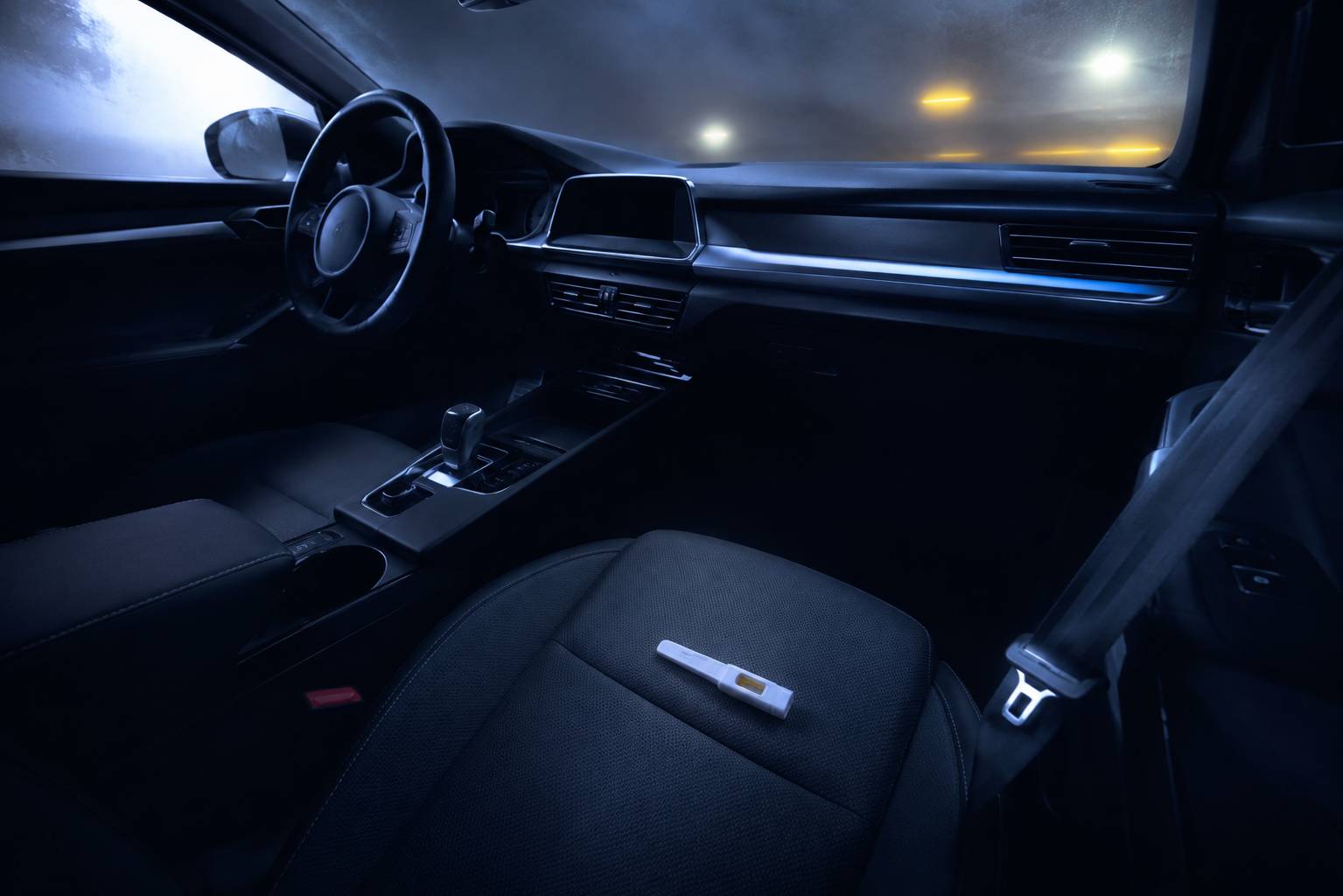 Intérieur de voiture avec volant générique et éthylotest posé sur le siège passager